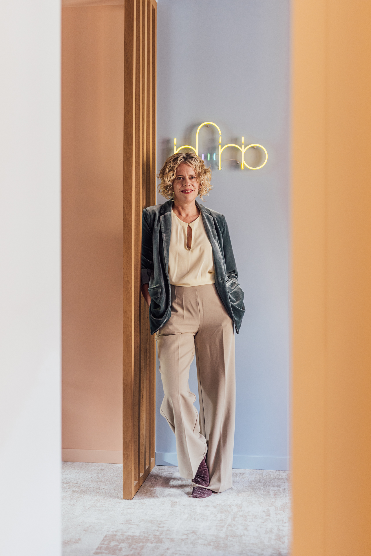 Ann Verlinden bij het Infinio-neonlogo in haar kantoor